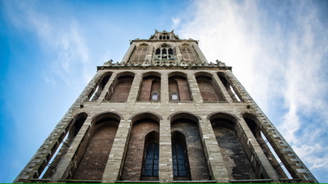 Een toren van onderaf gezien, met lijnen die naar de hemel leiden.