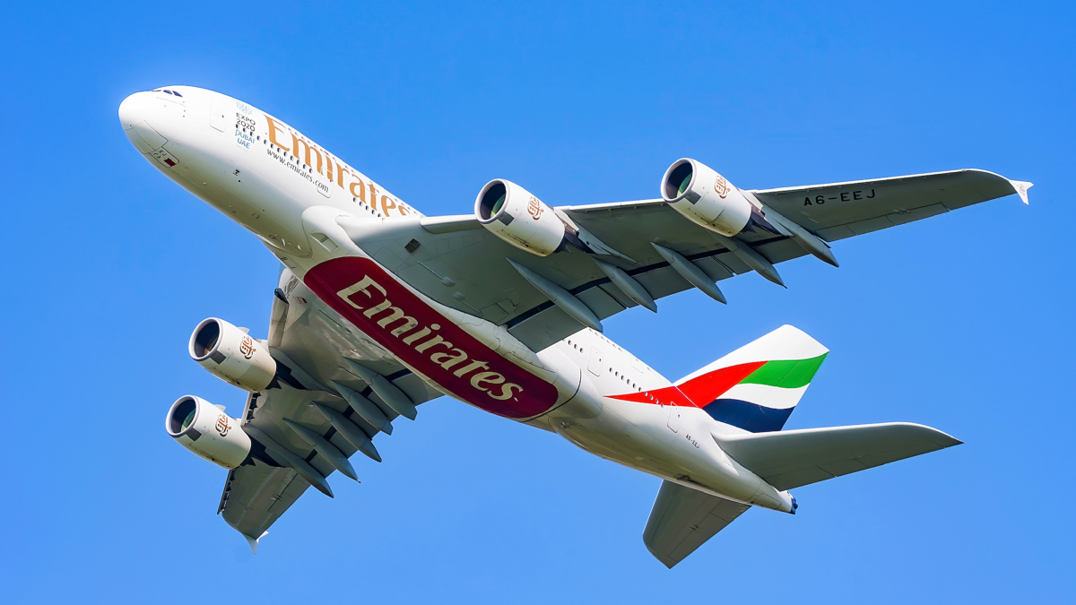 Emirates Airbus A380 van onderen gezien tegen een blauwe lucht