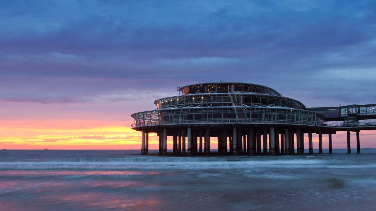 Scheveningen en de zee – De pier van Scheveningen bij schemering tegen een kleurrijke lucht