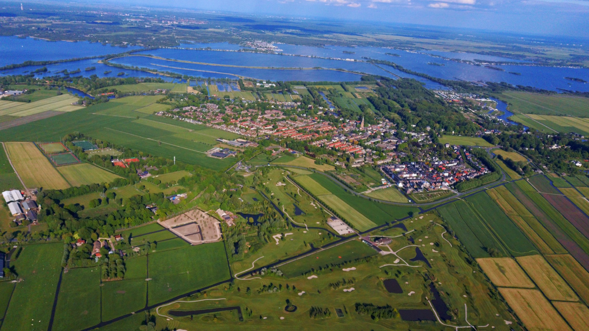 Luchtfoto van een stad aan een meer omgeven door groen