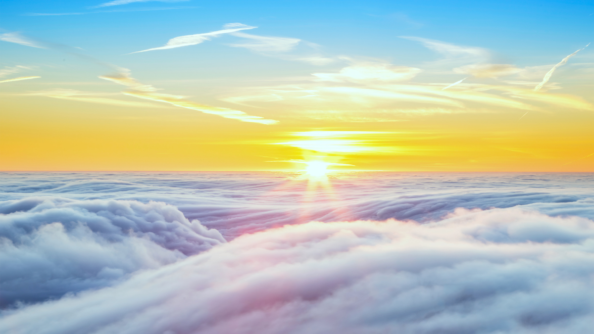 Zonsopkomst boven een wolkendek met een gele lucht