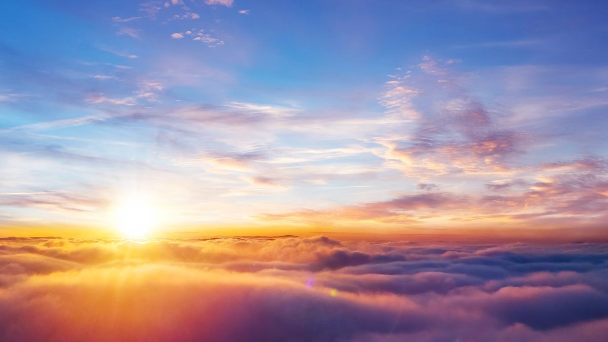 De zon komt op boven een dik wolkendek in warme kleuren. (drone)